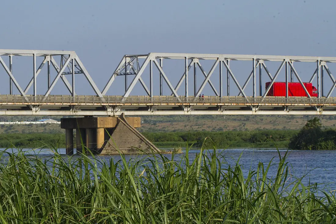 A track and pedestrians cross the Albert Nile bridge in Northern Uganda